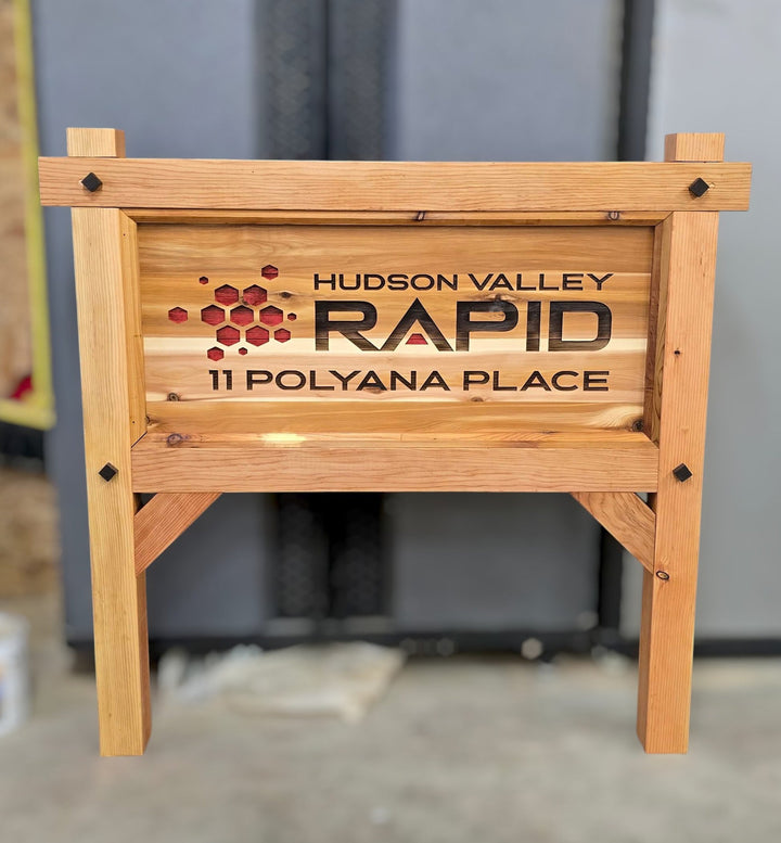 Wooden business sign with engraved text and logo in an indoor setting